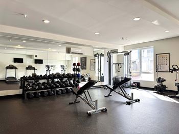 A gym with a variety of equipment including weights and cardio machines at Spyglass Hill Apartments, Bremerton, 98337